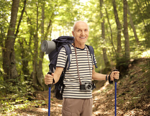 Happy senior hiker posing in a forest