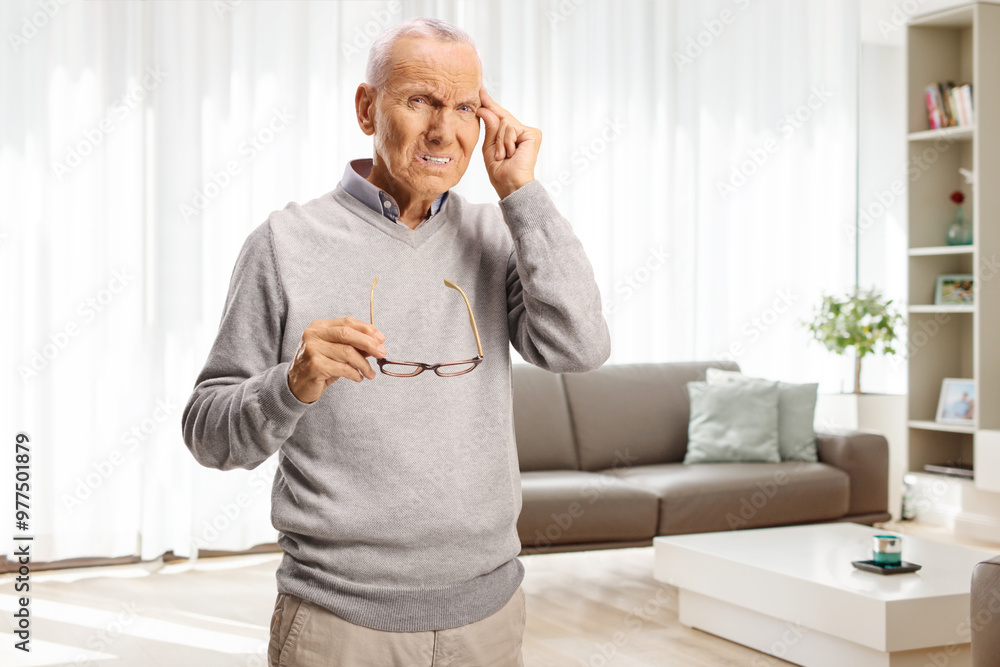 Sticker Elderly man with headache holding glasses and his forhead