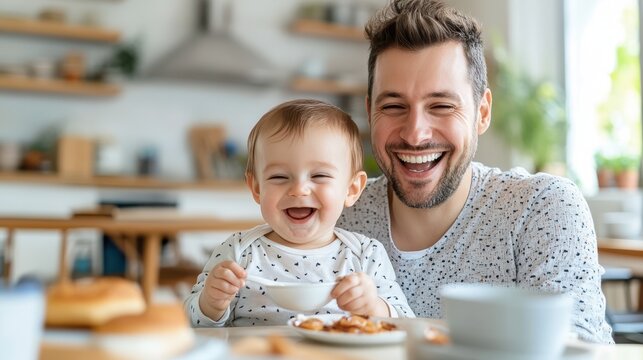 A cheerful father and baby share a breakfast moment, laughing in a cozy kitchen setting, highlighting fatherhood, joy, and shared family experiences during meal time.