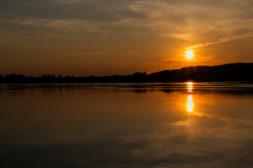 Naklejka premium The sun is beautifully setting over a tranquil body of water