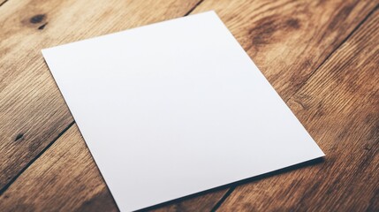 A blank white paper laying at a slight angle on a warm wooden desk, creating a calm workspace environment.