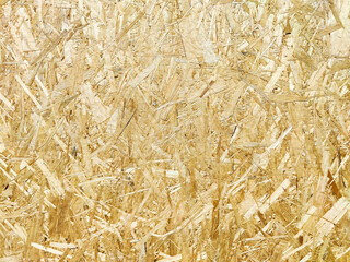 Close-up view of textured oriented strand board in natural shades under bright lighting