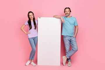 Full size portrait of positive partners stand near empty space huge phone screen isolated on pink color background © deagreez