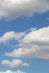 A beautiful blue sky adorned with fluffy white clouds, perfect for creating a serene and tranquil atmosphere.