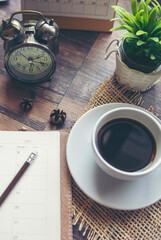 Agenda, planner book, calendar, pencil, and cup of coffee place on business office desk. Diary for...