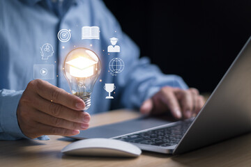 E-learning graduate certificate concept. Man holding light bulb Show Graduation hat, program Learning Educational Course to Develop Skill Through Internet on Website or Application with Computer