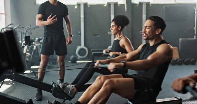 Workout, rowing machine and instructor with group in gym for wellness, sports or body health. Coach, club and people exercise on ergometer for fitness, muscle and cross training for cardio with pain