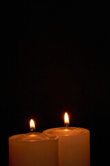 Candles burning against a black background illuminate a hope of faith