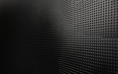 Abstract black and white background of a metal sheet with a grid of holes. The image has a modern and minimalist feel.