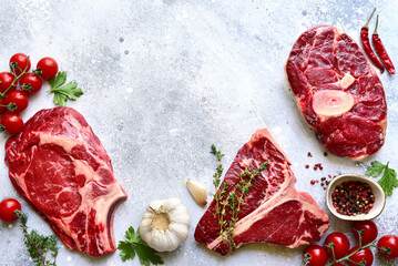 Different types of raw marbled beef steaks : T-bone, ossobuco, spider and rib eye with ingredients...