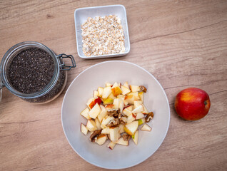 A healthy breakfast made of apple, oatmeal, plain yogurt, walnuts, hazelnuts and chia seeds guarantees a great start to the new day.