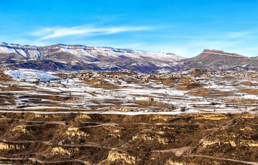 The village in the basin is surrounded by high mountains in the winter