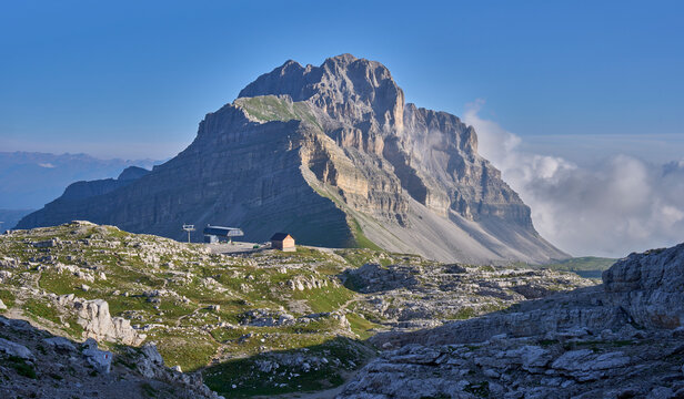 A mountain landscape with cargo cable car in the foreground as seen from Passo del Groste in Brenta Dolomites, Italy. Mountain Pietra Grande in the background. 