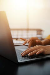 Close up Business woman using calculator and laptop for do math finance on wooden desk, tax,...