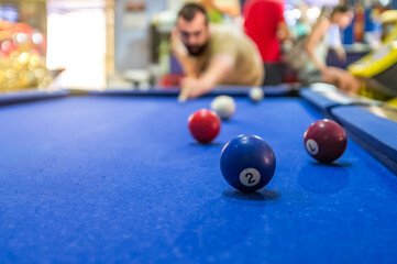Man Playing Billiards in a Lively Game Room