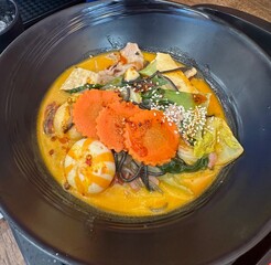 Black Noodle Mala Soup with Meatball, Carrots, Tofu, and Vegetables in Creamy Milk Broth