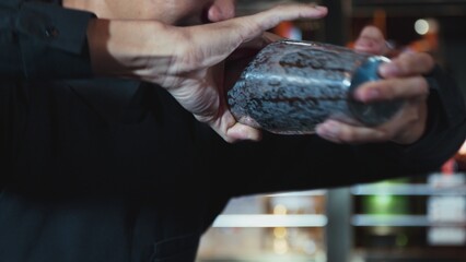 Closeup Asian bartender shaking mixed all ingredients alcohol liquor and syrup tasty with shaker presentation in special refresh drink showcasing nightlife mixology at luxurious nightclub. Vinosity.