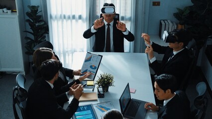 Top view of manager working on laptop and sending data analysis to business people by using VR glass headset while diverse team planning marketing strategy and looking at financial graph. Directorate.