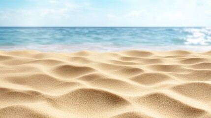 Obraz premium A beach with a clear blue ocean in the background. The sand is dry and the water is calm