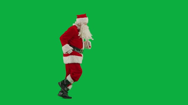 Portrait of man dressed as Santa on chroma key green screen background. Santa Claus in red outfit with beard and mustache running. Side view.