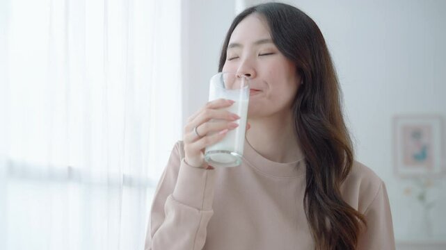 Asian woman drinking milk from glass, health care concept
