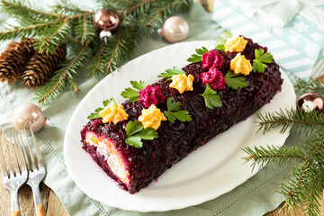 Christmas appetizer New year meal idea. Festive layered salad. Christmas New Year vegetable salad roll with herring and boiled vegetables.
