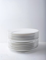 Obraz premium A white ceramic dinner plate set, neatly stacked on a white background