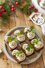 Christmas appetizer New year meal idea. Creative appetizer christmas. Creamy pate sandwiches of herring on a rye bread on the rustic table.