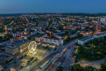 Large colorful Ferris wheel in city center. Aerial drone view on Colorful Ferris wheel spinning in the city center Dabrowa Gornicza Poland. Colorful Ferris wheel From a bird's eye view drone at night.
