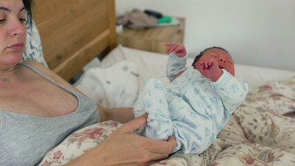 Exhausted mother resting with newborn on her chest, eyes closed, in a peaceful yet weary embrace,...