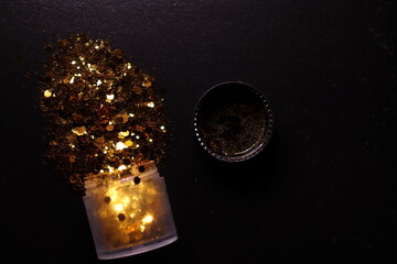transparent jar with golden shiny shiny glitter on a black background