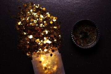 transparent jar with golden shiny shiny glitter on a black background