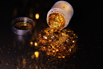 transparent jar with golden shiny shiny glitter on a black background