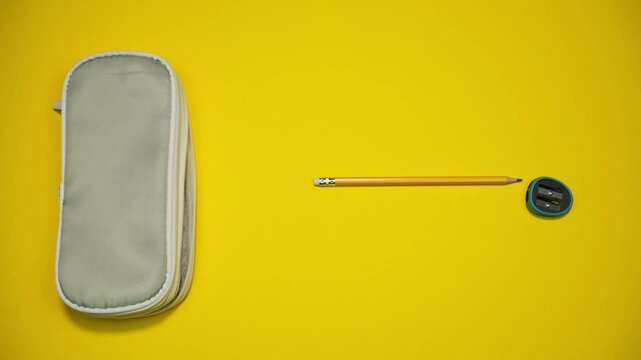 School supplies move out of the pencil case with different speed (pencils, ruler, paper notebook, scissors, sharpener). Stop motion SCHOOL animation, 4k, banner copy space
