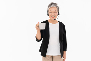 Call center. Caucasian mature middle-age woman hotline worker IT support manager in headset holding...