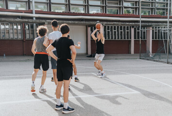 Group of friends enjoying a casual basketball game at an old neighborhood court, capturing fun and friendship on a sunny day.