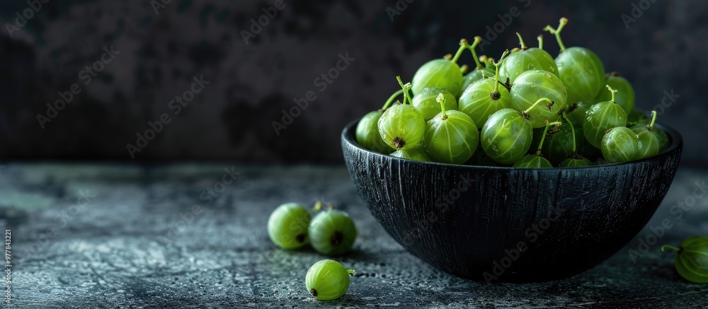 Poster Fresh gooseberries in a bowl on a dark background. Copy space image. Place for adding text and design