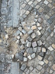 Defective sidewalk, individual stones are loose and no longer present 