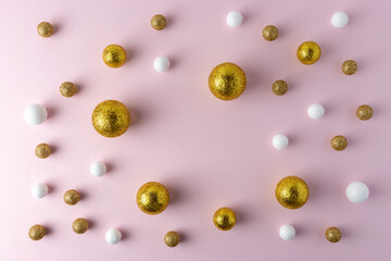 Golden and white glitter balls on pink background. Minimal Christmas or New Year concept.