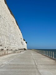 white cliff beside the sea with pavement