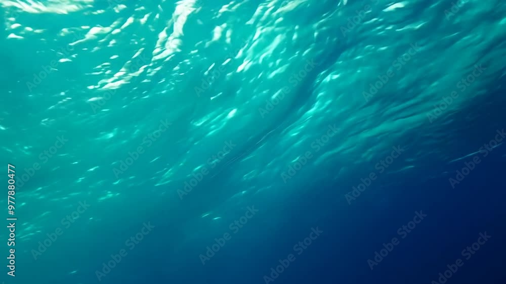 Poster rays of sunlight are filtering through the surface of a wavy ocean creating an abstract pattern of l