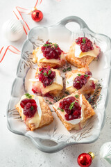 A tray of food with cranberries and cream on top