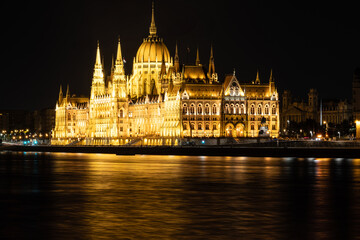 Obraz premium Budapest, Hungary. August 24, 2022. Amazing night shot of the parliament. The lighting enhances the beauty and elegance of the building. Three-quarter view from the Danube river side.