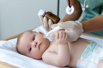 Nurse gives oral remedy to newborn in the hospital room