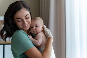 Beautiful nurse medical worker in gloves holding newborn baby in hands