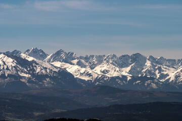 Ośnieżone szczyty górskie - góry Tatry. Widok z wieży widokowej na szczycie góry Koziarz w Beskidzkie Sądeckim. Panorama Tatr - zbliżenie
