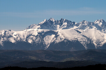Ośnieżone szczyty górskie - góry Tatry. Widok z wieży widokowej na szczycie góry Koziarz w Beskidzkie Sądeckim. Panorama Tatr - zbliżenie © AFilipczuk