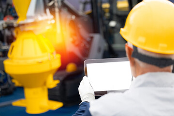 Engineer worker uses computer tablet to configure equipment. Service diagnostics and repair of...