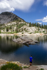 Lake Mary in the mountains of Brighton Utah, caucasian man resting after hike overlooking lake
