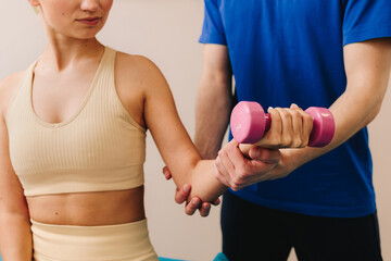 Therapist is helping patient to restore arm movement after illness. Doctor is helping with physiotherapy to restore body functioning. Effective PT to heal from injury. © Rabizo Anatolii